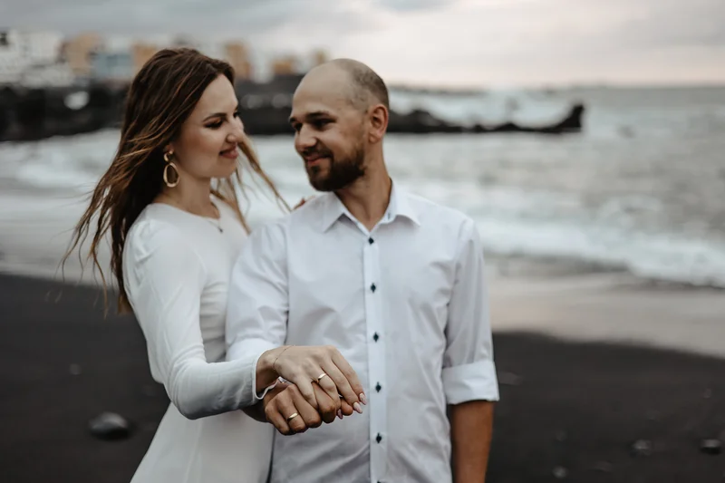 Intymny portret pary na czarnej wulkanicznej plaży w Puerto de la Cruz