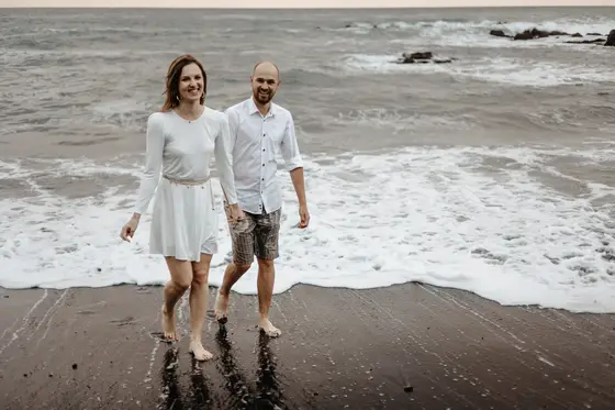 Lovers embracing on dramatic volcanic rocks above ocean in Tenerife