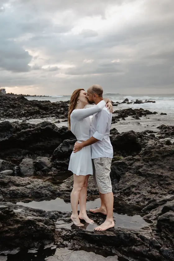 Intimate kiss on volcanic coastline Puerto de la Cruz Tenerife romantic session