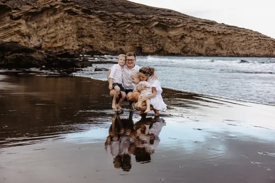 Magical family reflections in wet sand on Tenerife volcanic beach during photography session