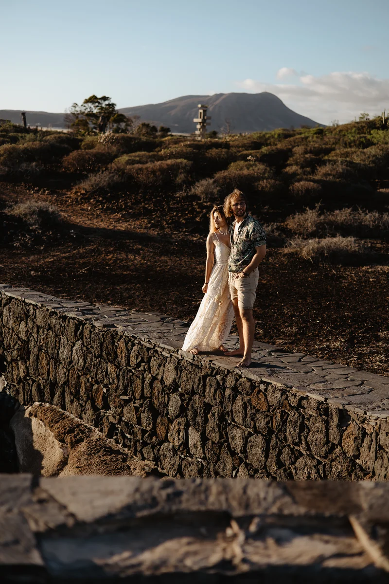 Enamorados en puente histórico de piedra con montañas y paisaje tinerfeño de fondo