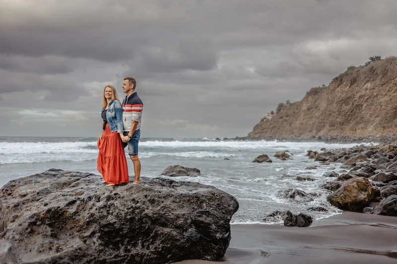 Romantyczny portret pary na wulkanicznych skałach plaży Socorro Teneryfa podczas sesji rodzinnej lifestyle fotografa