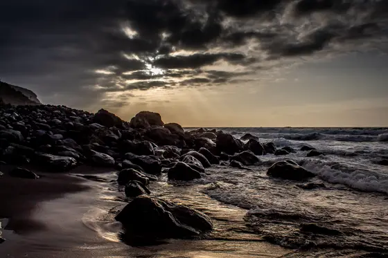 Paisaje dramático de la playa volcánica Socorro en Tenerife con rocas negras y espuma blanca