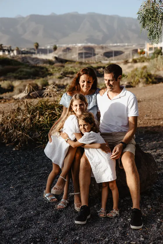 Happy family during photo session in South Tenerife with mountains backdrop and natural lighting