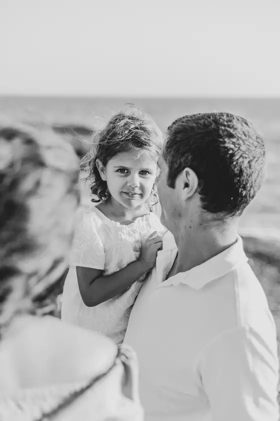 Father with daughter in black and white portrait during photo session on rocky South Tenerife coastline