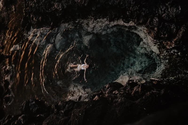 Costa volcánica de Tenerife con piscinas naturales y modelo bajo la cálida luz del sol poniente o naciente