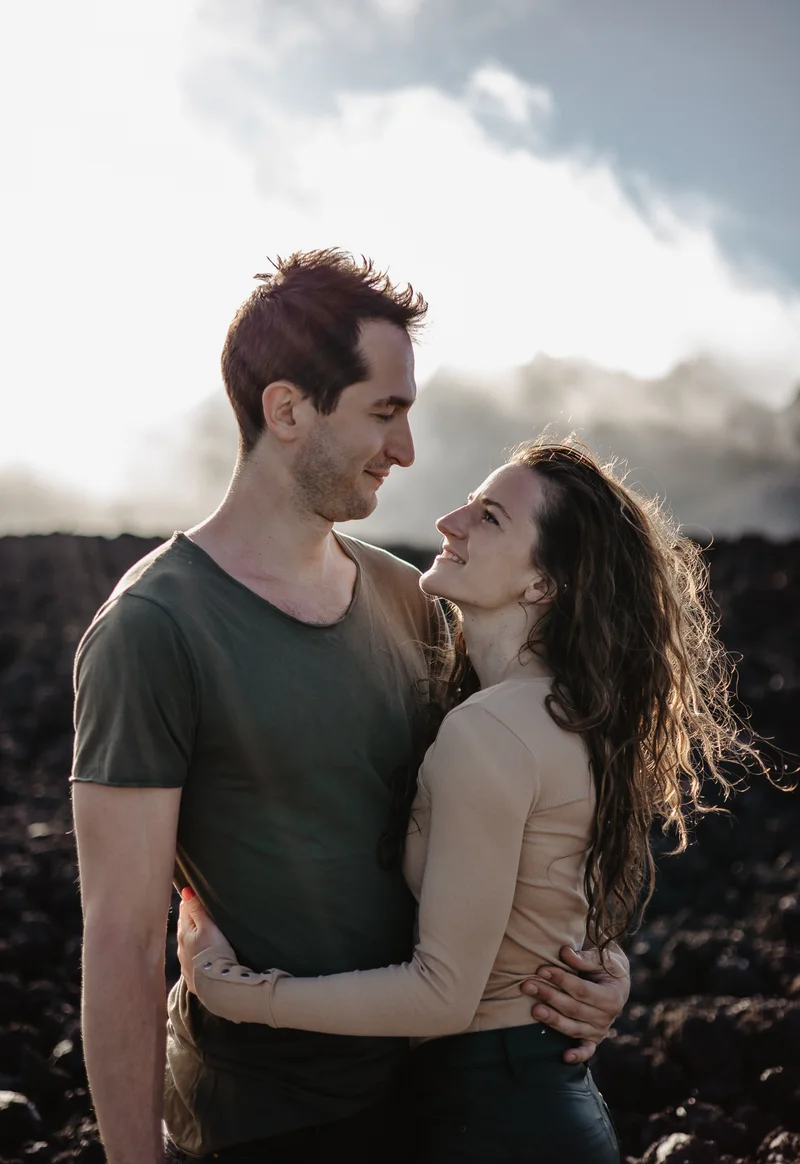 Fotografía parejas Teide pareja romántica abrazándose contra formaciones rocas de lava en luz dorada