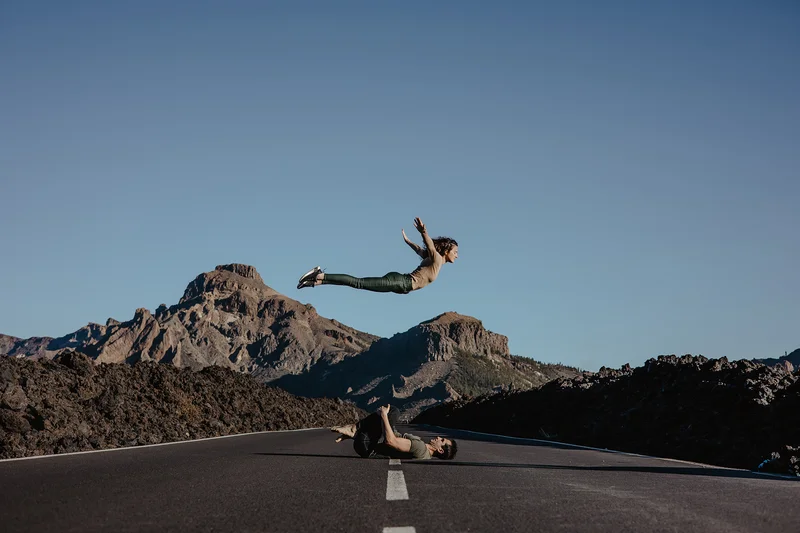 Fotografía parejas Teide espectacular pareja acrobática saltando en carretera con vistas montañas volcánicas