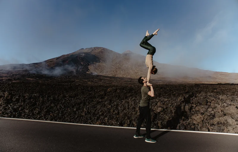 Fotografía parejas Teide pareja acrobática en carretera con volcán y nieblas al fondo