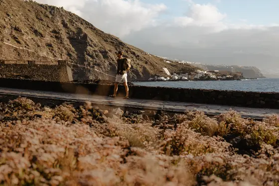 Mujer de pie en piscina natural de roca en la costa de Tenerife con vista a las aguas del océano