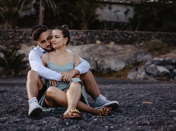 Stylish Spanish couple posing on Tenerife's rocky coastline in golden sunset light