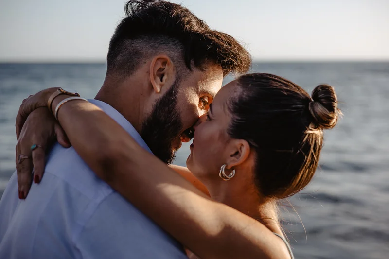 Tierno beso de pareja española en luz dorada del atardecer en Tenerife