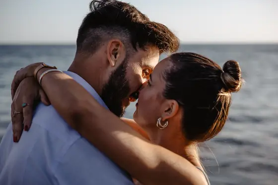 Tender kiss of Spanish couple in golden sunset light on Tenerife