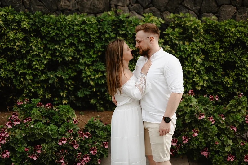 Pareja enamorada en jardín tropical en Tenerife rodeada de flores coloridas y vegetación