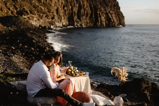 Picnic romántico de compromiso junto al océano en Tenerife con acantilados volcánicos espectaculares