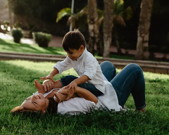 Father leaning over family lying on grass during family photography Tenerife tropical session
