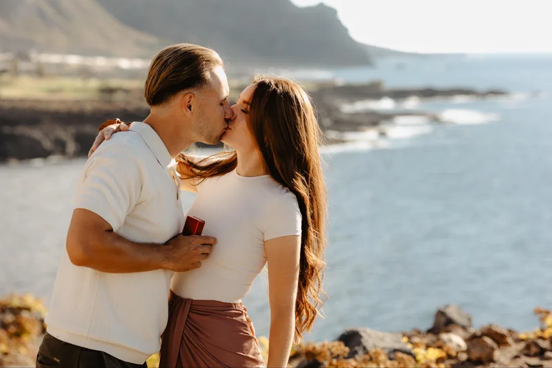 Pareja besándose junto al océano durante una sesión de compromiso en Tenerife