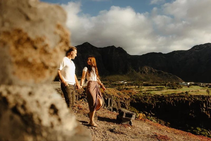 Pareja caminando de la mano por terreno rocoso de Tenerife
