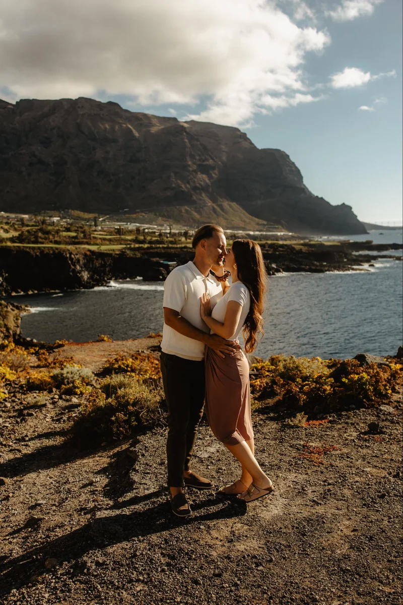 Pedida de mano romántica en Tenerife, hombre arrodillado ante su pareja en la costa rocosa del océano