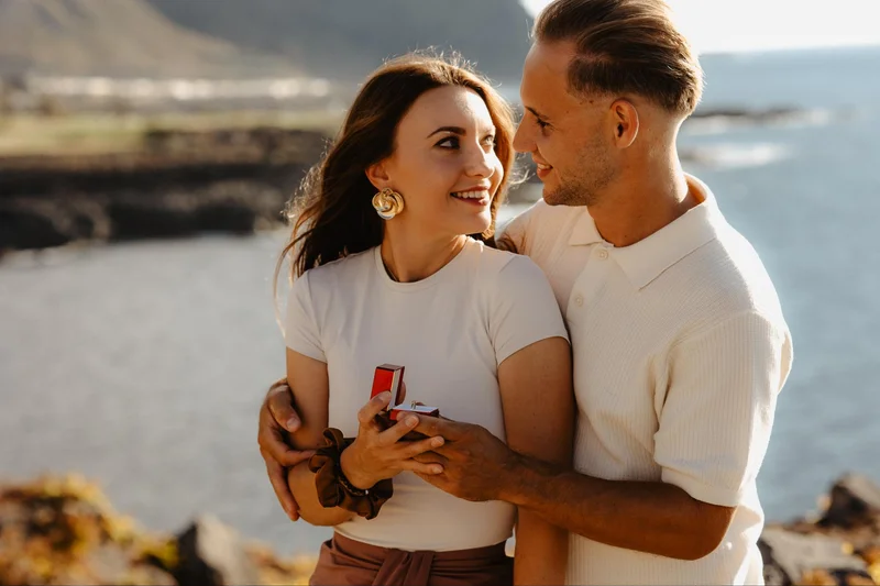Pareja feliz tras el compromiso con el océano y acantilados de Tenerife