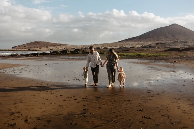 Familia tomada de manos playa Tenerife sesión familiar vacaciones unidad amor montaña