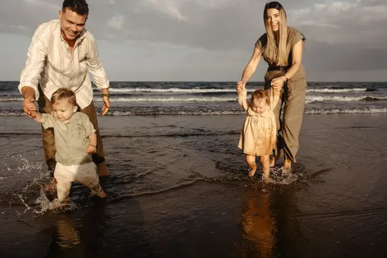 Family playing in ocean water Tenerife family session vacation children's joy beach