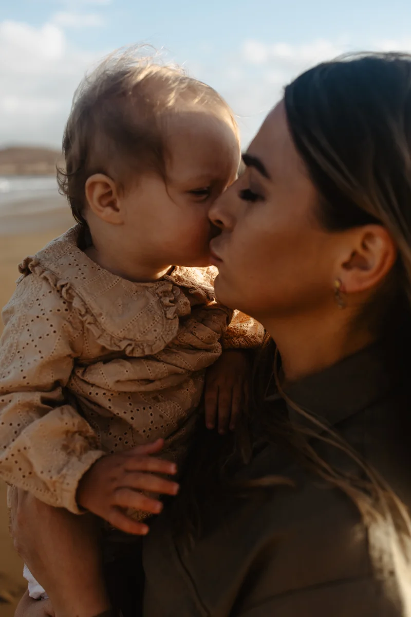Momento íntimo entre madre y niño Tenerife sesión familiar vacaciones amor tierno océano fondo