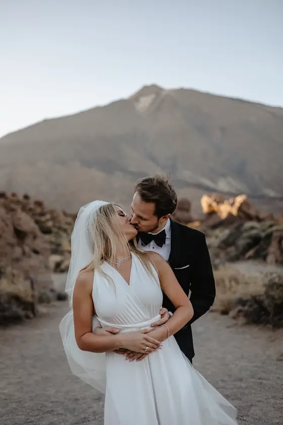 Romantic newlywed kiss Tenerife wedding session volcano background veil golden hour love