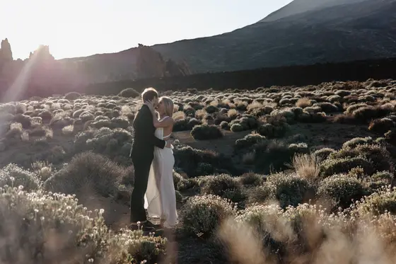 Romantic newlywed embrace Tenerife wedding session volcanic vegetation sunset golden hour