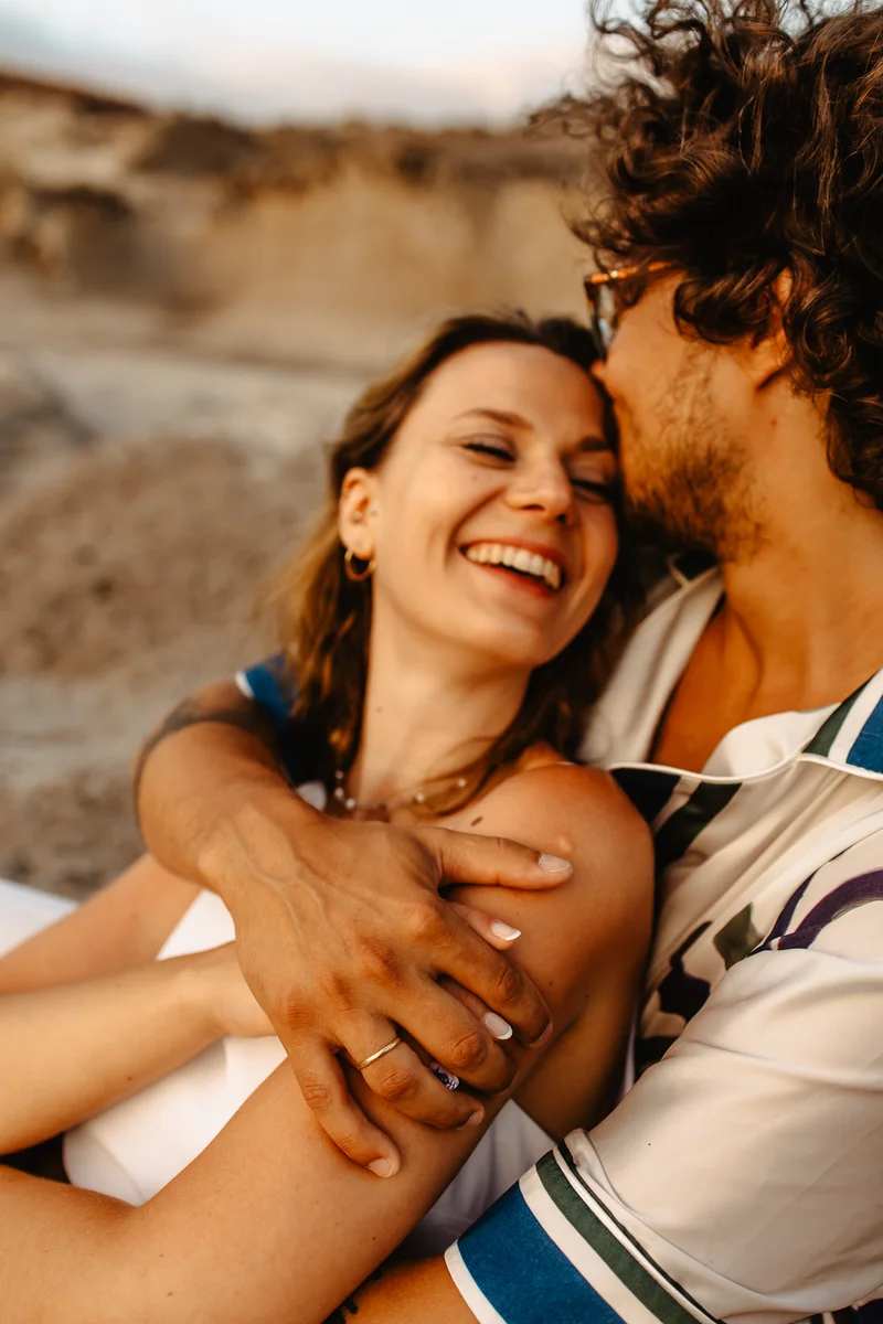 Pareja feliz primer plano riendo durante sesión fotografía familiar naturaleza en entorno natural Tenerife salvaje