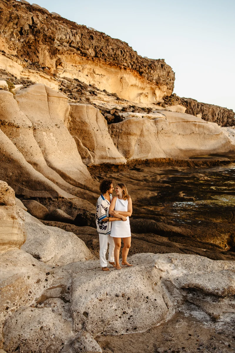Pareja de pie en formaciones rocosas durante sesión fotografía familiar naturaleza en áreas salvajes Tenerife