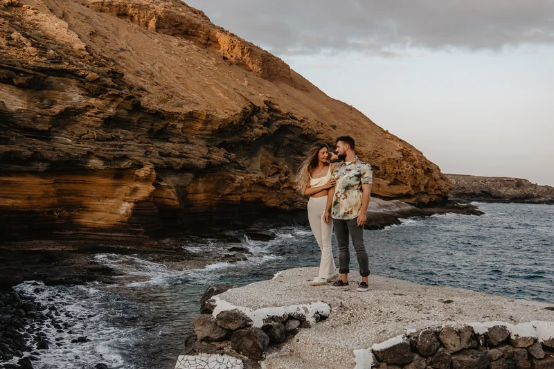 Pareja romántica en plataforma rocosa sobre mar Montaña Amarilla Tenerife fotógrafo bodas